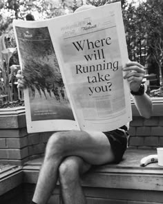 a man sitting on a bench reading a newspaper