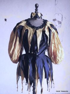 a mannequin dressed in black, gold and blue with ruffles on it