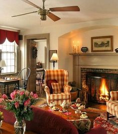 a living room filled with furniture and a fire place in the middle of it's fireplace