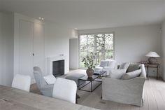 a living room filled with furniture and a fire place in front of a large window