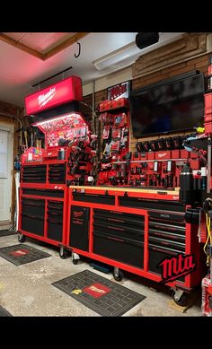 a garage with many tools on the floor and in front of it is a television