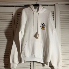 White Sweatshirt With Small Design On Front And Large On Back. 23.5 Inches Across The Chest. Care Tag Pictured. Kangaroo Pocket And Hood. Strain From Factory Or Store. Mickey Mouse Sweatshirt, Small Design, Care Tag, Disney Tops, Disney Style, White Sweatshirt, Small Designs, Kangaroo Pocket, Kangaroo