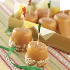 small desserts with toothpicks in them are on a table next to other food items