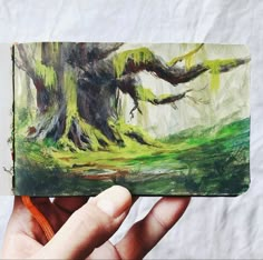 a person holding up a piece of art that looks like a tree in the woods