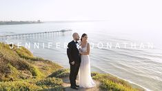 a bride and groom standing on a cliff overlooking the ocean