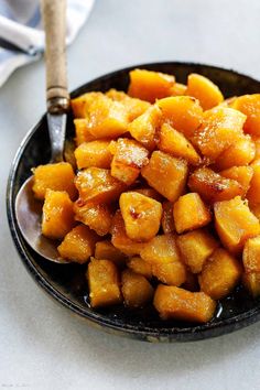 a black bowl filled with cut up sweet potatoes