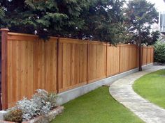 a large wooden fence next to a lush green yard