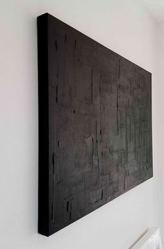 a black piece of art hanging on the wall