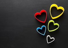 four heart shaped cookie cutters on a black surface