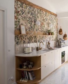 the kitchen is decorated with wallpaper and wooden shelves