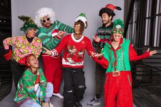 a group of people dressed in ugly christmas sweaters