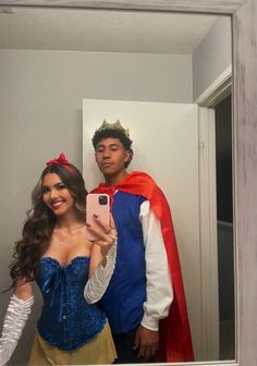 a man and woman dressed up as princesses taking a selfie in a mirror