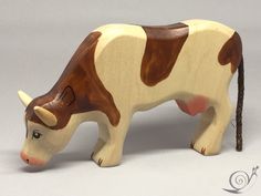 a wooden toy cow standing on top of a table