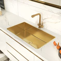 a kitchen sink with gold faucet and marble counter top