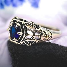 Get ready to fall in love with this breathtaking vintage piece! Crafted from genuine 925 sterling silver, this stunning ring features a mesmerizing simulated royal blue sapphire at its heart. The intricate filigree design adds a touch of timeless elegance, making it a must-have for any jewelry collection. And yes, it's stamped with 925 to assure you of its authenticity and quality. Don't miss out on owning this exquisite treasure! Antique Engraved Ring With Intricate Design In Sterling Silver, Antique Sterling Silver Engraved Ring With Intricate Design, Silver Sapphire Ring With Intricate Design, Victorian Filigree Ring In Sterling Silver, Silver Victorian Sapphire Ring For Gift, Victorian Style Silver Sapphire Ring As Gift, Victorian Sterling Silver Ring With Center Stone, Victorian Style Silver Sapphire Ring Gift, Vintage Sapphire Jewelry With Intricate Design