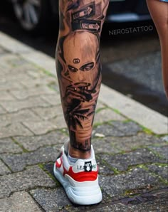 a man's leg with tattoos on it and a red stripe around the ankles