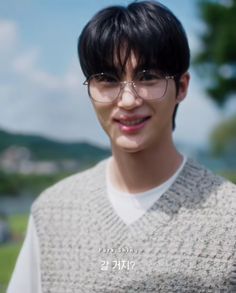 a young man wearing glasses and a sweater vest