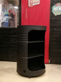 a black metal shelf sitting in front of a red door