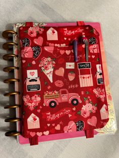 a red notebook with hearts and flowers on it