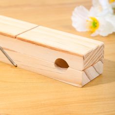 a piece of wood with a hole in the middle on a table next to flowers