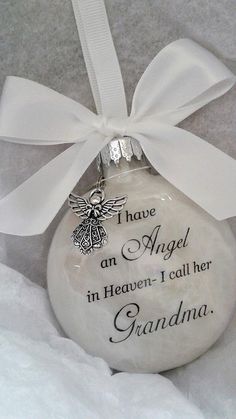 a glass ornament with an angel on it and the words grandma written in black ink