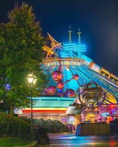 an amusement park at night with lights and rides