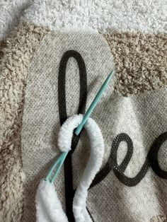 a pair of scissors laying on top of a knitted piece of cloth with the word peace written across it