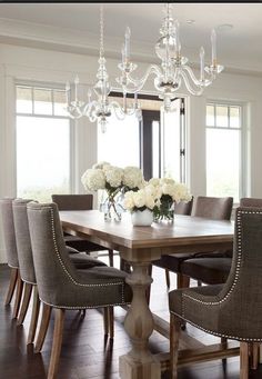 a dining room table with chairs and chandelier