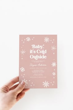 someone holding up a pink baby it's cold outside card with snowflakes