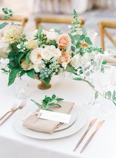 a table set with place settings and flowers