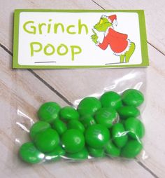 green candy candies in cellophane wrapper on wooden floor with name tag