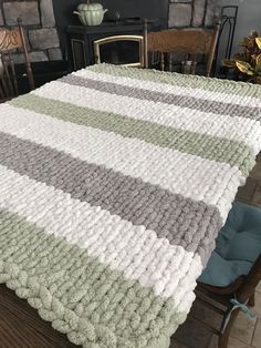 a table with a blanket on top of it in front of a fire place and fireplace