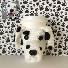 a crocheted coffee cup holder with a dog's face on it