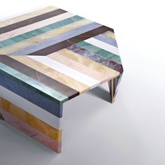 a multicolored wooden table sitting on top of a white floor