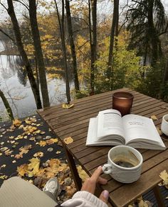 a person sitting at a table with an open book and cup of coffee on it