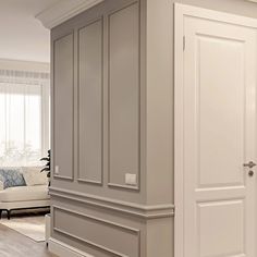 an empty living room with white furniture and wood floors