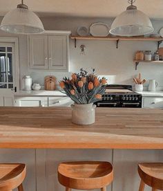 a vase filled with flowers sitting on top of a kitchen counter