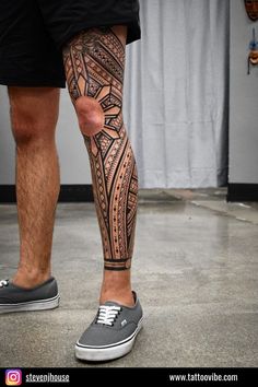 a man's leg with an intricate tattoo design on the lower part of his leg