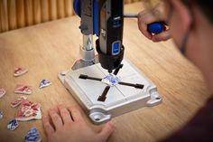 a man is using a machine to cut up hearts on a table with other items