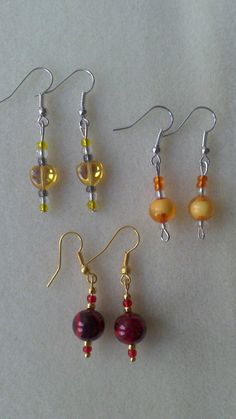 Three pairs of beautiful, unique, handmade earrings, two pairs with silver coloured wire, yellow and orange beads, one pair with gold coloured wire and red beads. Ships worldwide from UK. Amber Beaded Earrings For Gift, Handmade Amber Beaded Round Earrings, Handmade Amber Round Bead Earrings, Handmade Amber Earrings With Round Beads, Nickel Free Yellow Beaded Earrings For Gift, Nickel-free Yellow Beaded Earrings For Gifts, Nickel-free Yellow Beaded Earrings As Gift, Beaded Jewelry Earrings, Gold Bead Earrings