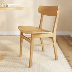 a wooden chair sitting on top of a hard wood floor next to a white rug