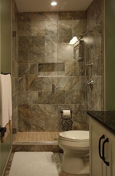 a bathroom with a walk in shower next to a toilet