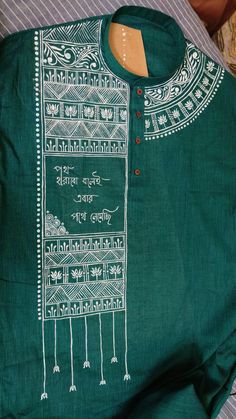 a green shirt with white designs on it