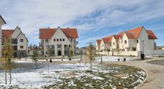 several white houses with red roofs in the snow