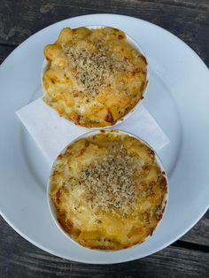 two small pizzas sitting on top of a white plate