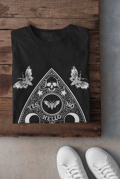 Thanks for stopping by! Ouija Board and Moths T-shirt Printed on a super soft, cotton tee Dispatched in 5 working days or sooner Unisex Free UK delivery Material: 100% ringspun cotton. Chest (to fit): S  34/36   M  38   L  40/42   XL  44/46   XXL  48/50 ECO-FRIENDLY Each garment is made to order, reducing extra material and energy that would be otherwise wasted We use DTG printing process which is easier on the environment than screen-printing Our ink is bright and also eco-friendly. Do not tumb Goth Trad, Tshirt Grunge, Pastel Goth Shirt, Grunge Tshirt, Emo Shirts, Black Balloon, Alt Clothing, Grunge Clothes, Grunge Tee