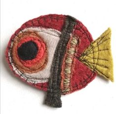 a close up of a small fish on a white surface with red and yellow colors