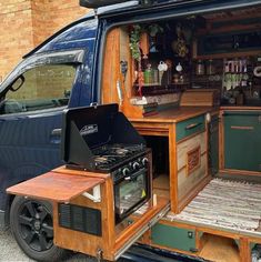 an open van door showing the kitchen and stove in it's back compartment, with shelves on either side