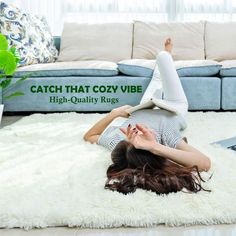 a woman laying on top of a white rug in the middle of a living room