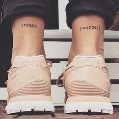 two people with small tattoos on their feet and one has the words create yourself written on them